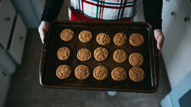 Person hält ein Backblech mit Keksen