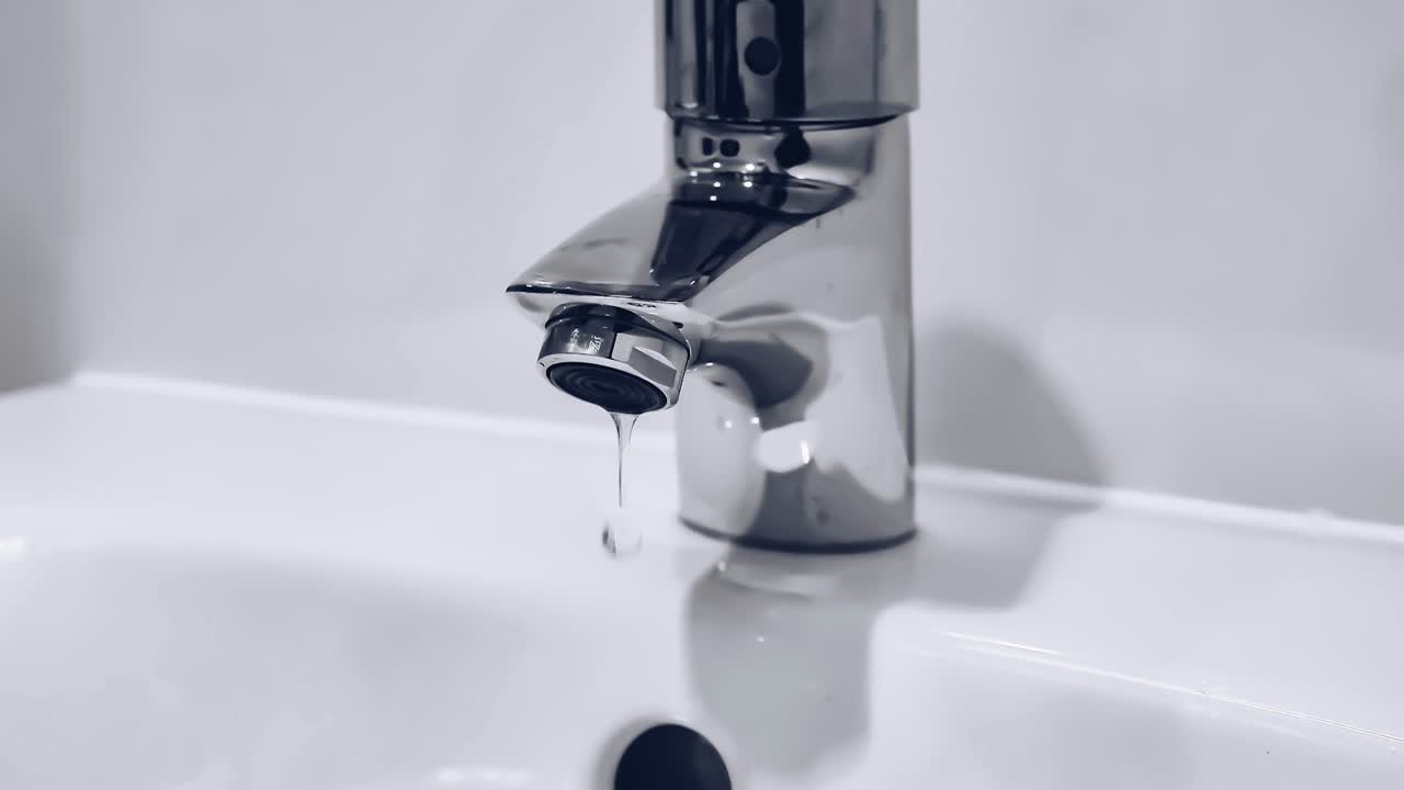 Verchromter Wasserhahn über einem weißen Waschbecken