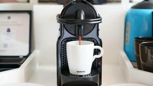 Kapselmaschine füllt eine weiße Tasse