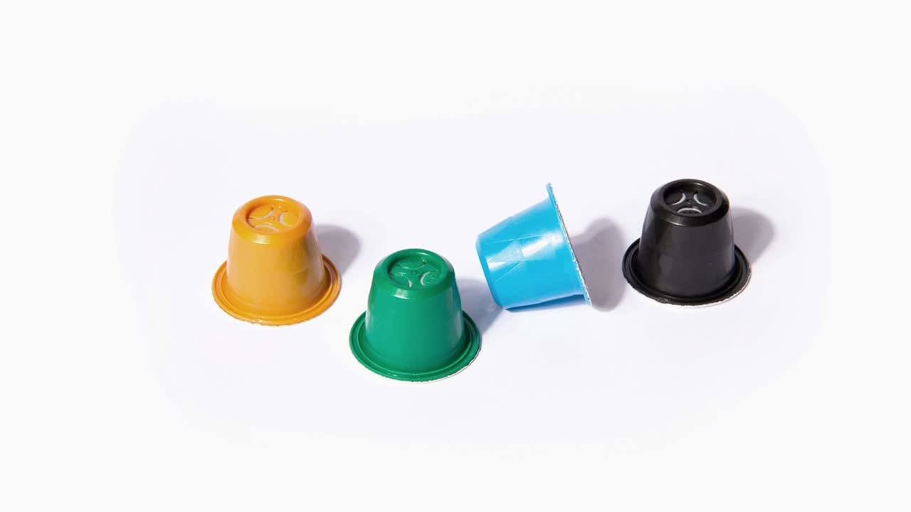 Drei bunte Kaffeekapseln auf weißem Hintergrund
