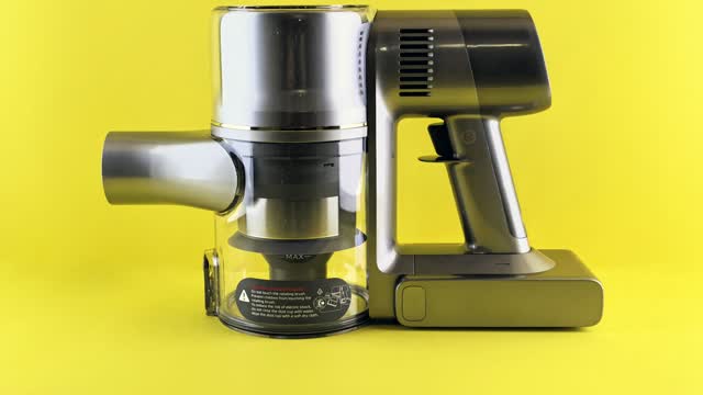 Moderner Akku-Staubsauger vor gelbem Hintergrund