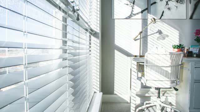 Weiße Jalousie mit Sonnenlicht am Fenster
