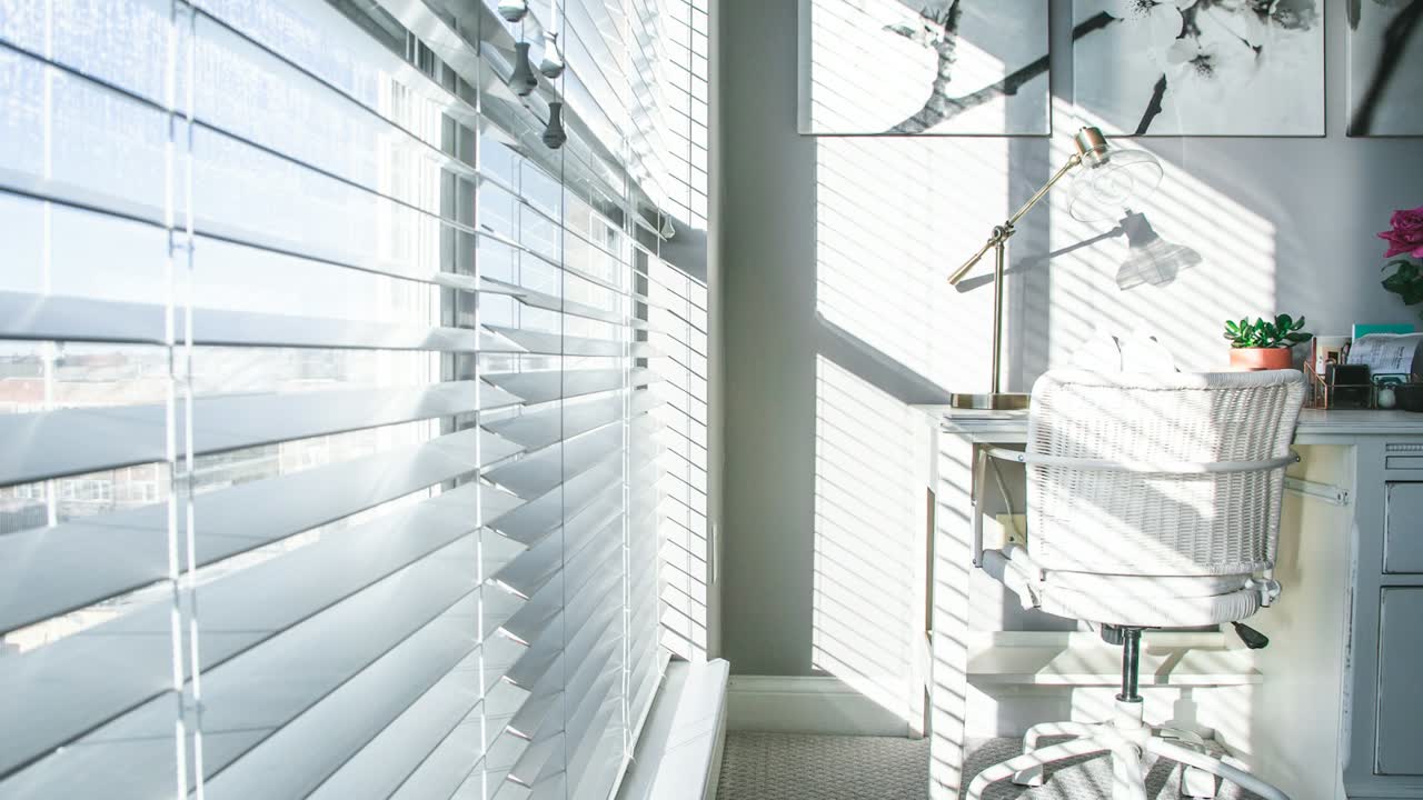 Weiße Jalousie mit Sonnenlicht am Fenster