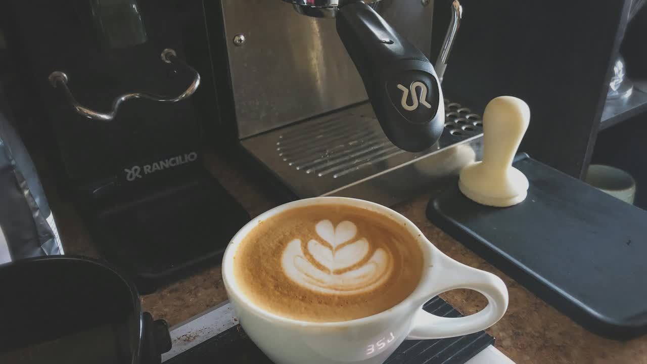 Cappuccino mit Milchschaum unter einem Kaffeevollautomaten