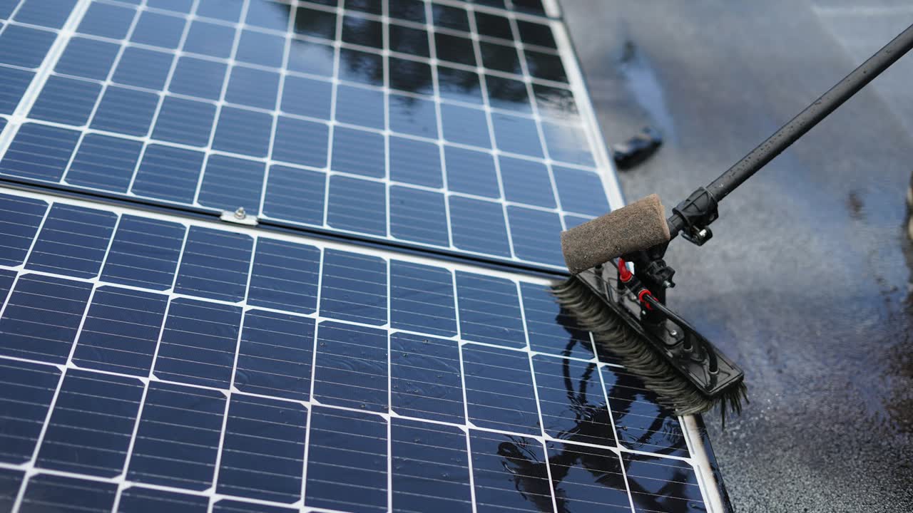 Solarmodul wird mit Bürste und Wasser gereinigt