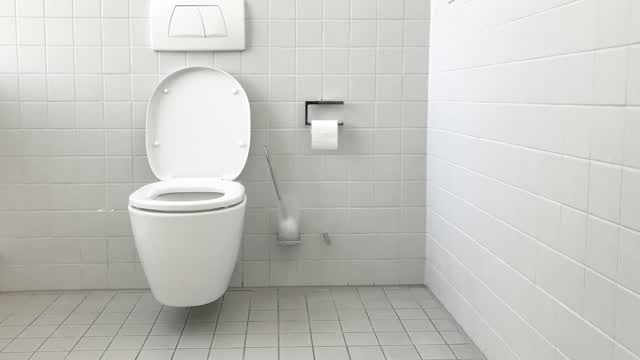 Wand-WC mit Drückerplatte in einem gefliesten Bad